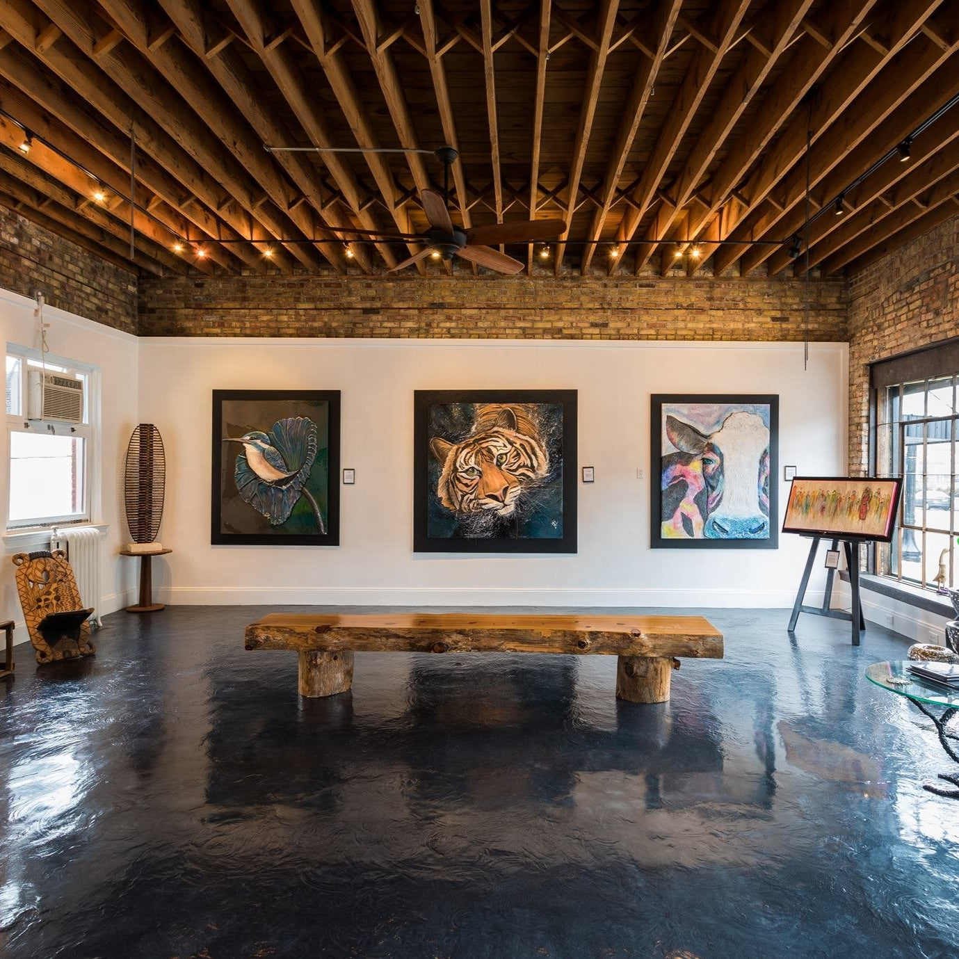 Modern interior with wooden beams, artwork on the wall, and a bench.